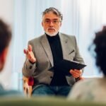Senior man psychiatrist talking with his patients during therapy session